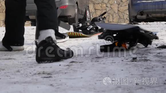 人们穿上鞋子，在山上停车场的汽车附近滑雪