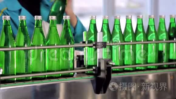 这条生产线的一名员工擦拭矿泉水用的绿色玻璃瓶