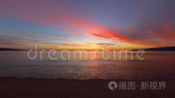 海滩上美丽的热带日出。 海浪冲刷着海湾上的沙子