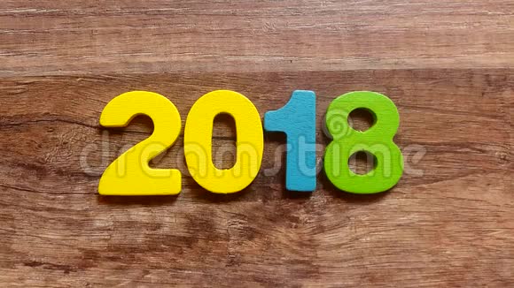 用手指从木桌上的彩色木制雕像上拿出2018年的数字短视频