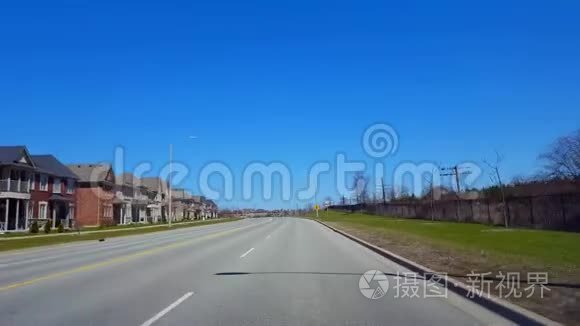 春日驾驶住宅道路.. 司机的观点POV沿着美丽的阳光街道