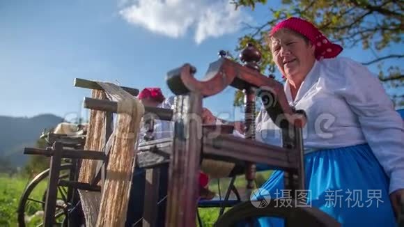 女人转动加工棉花的木制工具视频