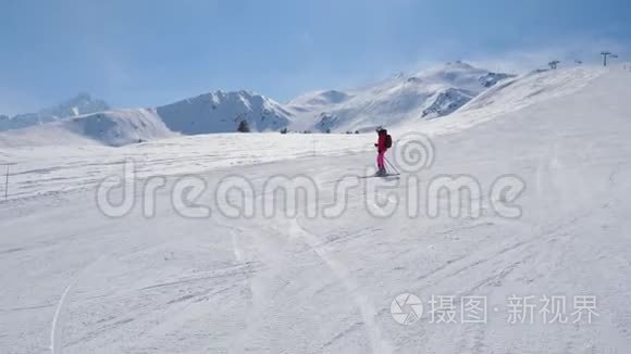 优雅的女子高山滑雪者滑下山坡视频