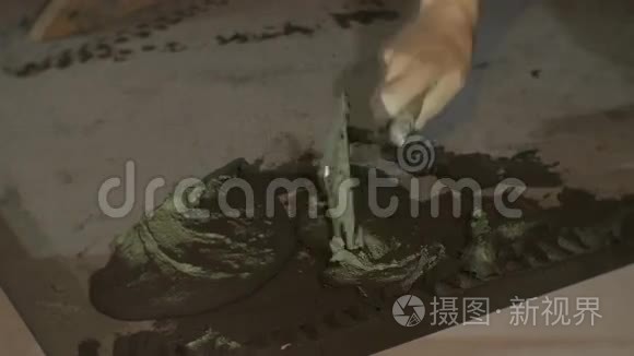 熟练工人在地板上涂手工湿水泥胶