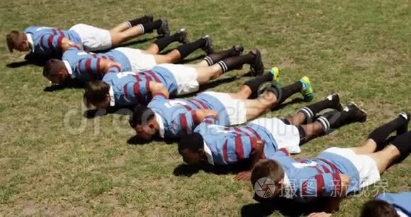 橄榄球队员在球场上做俯卧撑视频