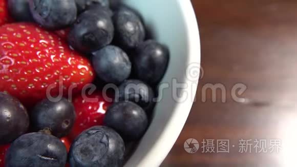 草莓和蓝莓放在白碗里准备吃视频
