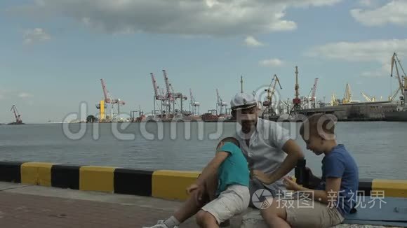 上尉和他的儿子坐在码头上