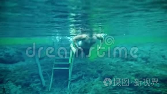 肌肉男在清澈的蓝色湖水中潜游视频