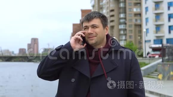 一个男人在城市景观的背景下用手机说话。