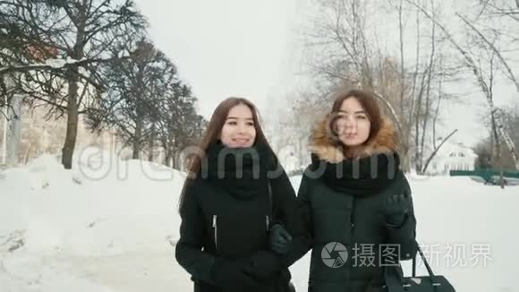 两个女人走过冬日的小巷，背景是雪树