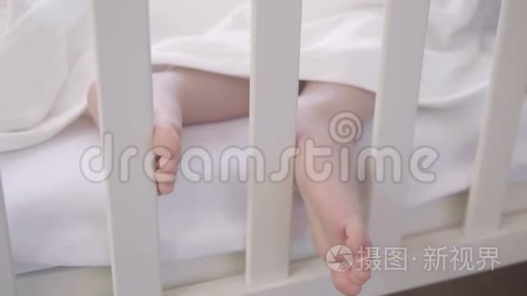 婴儿床上睡着的婴儿的腿视频