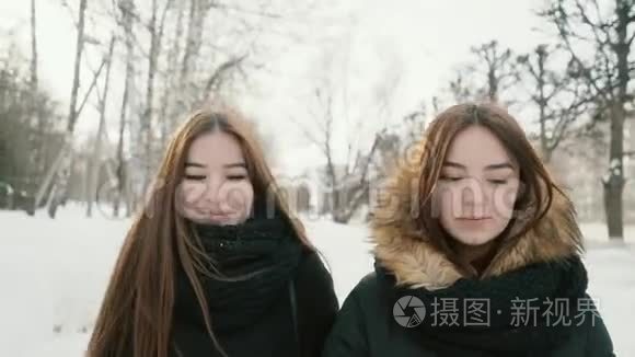 两个女人走过冬日的小巷，背景是雪树