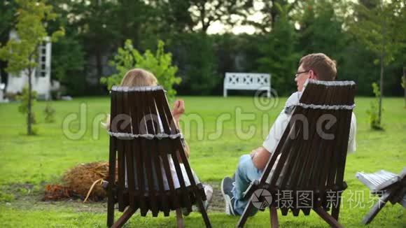 一对夫妇坐在乡间别墅的后院视频