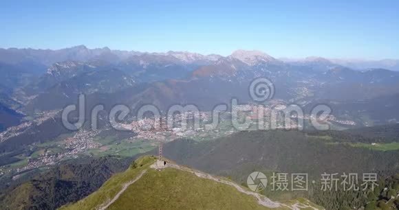 在一个晴朗而蓝色的日子里，可以看到塞里亚纳山谷和奥罗比阿尔卑斯山的空中景色。 山顶的十字架