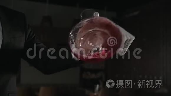 红酒倒在餐厅背景上的装饰器里。 与氧气混合