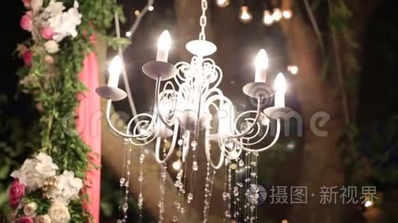 带有鲜花和花环的水晶吊灯闪耀在婚礼和派对上。 假日装饰，乡村风格。