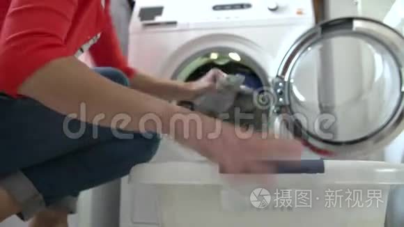 妇女从洗衣机上卸衣服