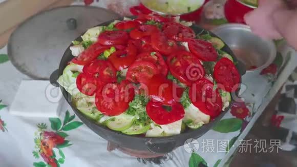 白色厨师的手，加入和切洋葱在切蔬菜的大锅与蔬菜。