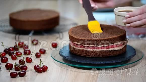 用樱桃准备巧克力蛋糕。 蛋糕用甜糖浆浸湿.