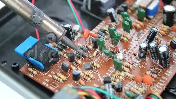 技术人员正在使用烙铁来修理电脑电路板的电子