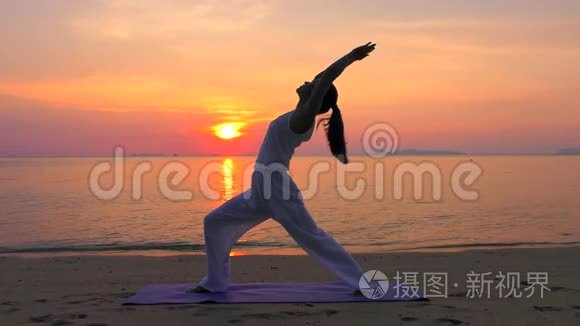 亚洲女子在日落海练习瑜伽
