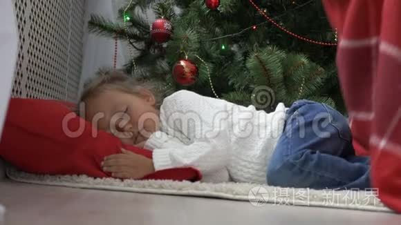 早上睡在圣诞树下的可爱小女孩