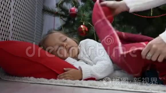 早上睡在圣诞树下的可爱小女孩