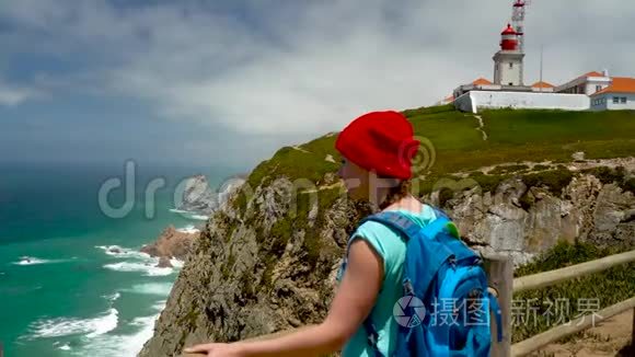 背着背包的女人可以欣赏灯塔附近的海洋海岸