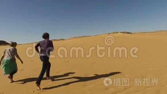 埃及沙漠中赤脚奔跑的夫妇