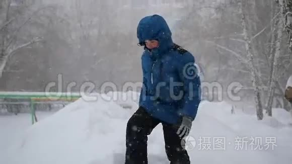 一个孩子跳进冬天公园的雪地里。 暴风雪