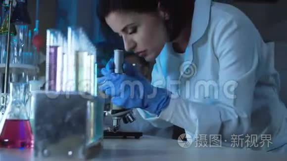 年轻的女科学家俯视显微镜视频