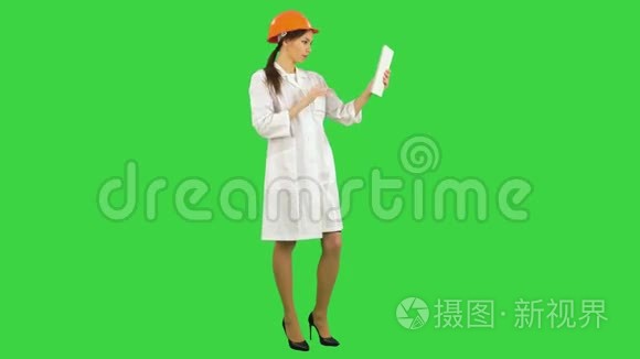 女工程师头盔有视频通话通过平板电脑上的绿色屏幕，铬键