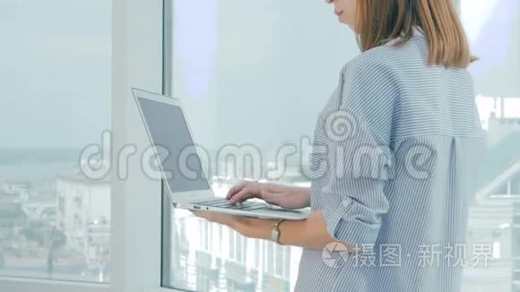不可辨认的女商人手在现代明亮办公室的笔记本电脑上工作。
