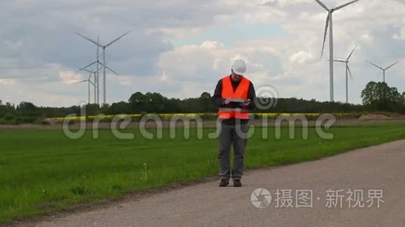 电气工程师在风车附近写作