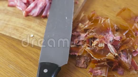 厨房桌子上的木板上的熏肠、刀和果皮。视频的预览图