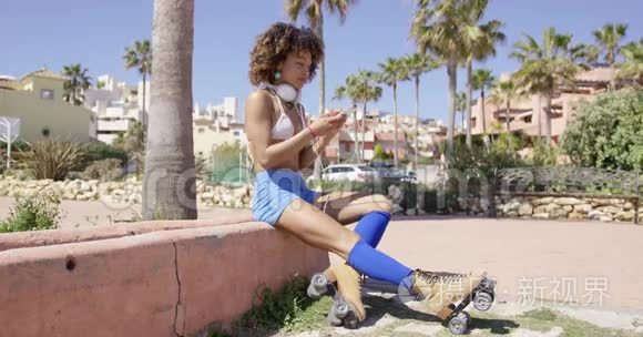 女性穿着溜冰鞋坐在路边视频