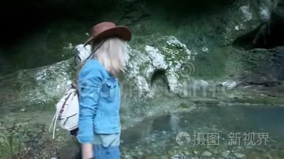两位年轻的高加索女性旅行者沿着一个热带洞穴旅行。 背上行军背包。 灵感来自于