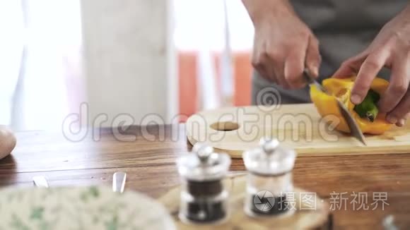 一名厨师在木板上切一根黄色的胡椒粉