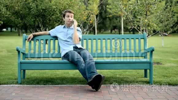 坐在长凳上讲手机的青少年视频