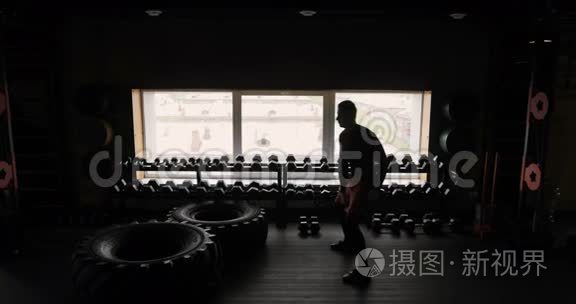 运动员的剪影与哑铃健身室黑色背景，男子与哑铃。 健身。