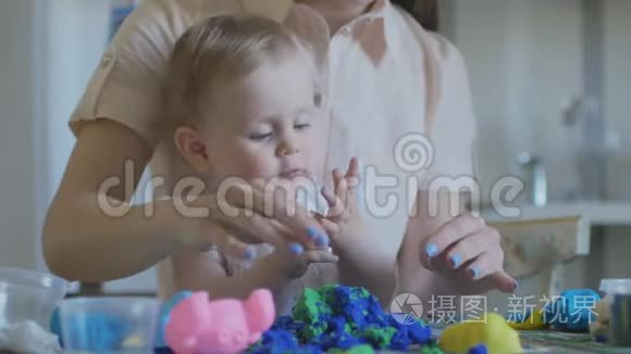 年轻迷人的保姆正在和婴儿玩塑料。 学前教育发展。