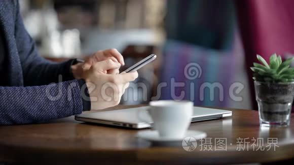 特写，男性手拿智能手机.. 咖啡馆里的一个年轻人使用智能手机，他在网上看到一些东西