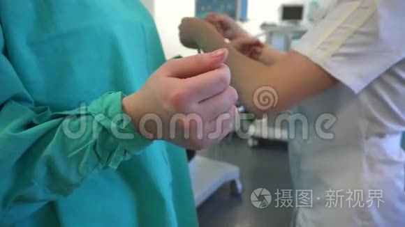 护士帮助外科医生穿着医用长袍视频