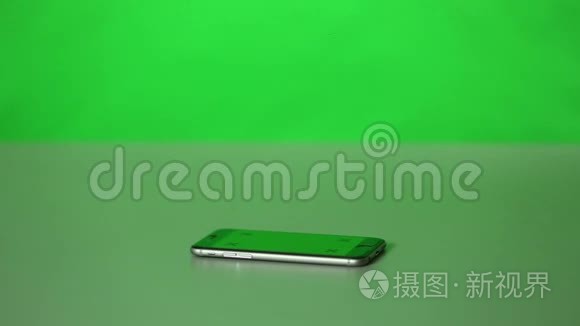 一个iPhone和一个办公桌上的绿色屏幕。