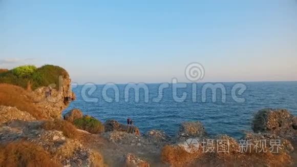 两个人站在海岸的岩石上视频