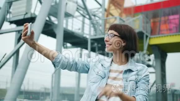 幸福的年轻女人在外面用智能手机相机自拍的肖像
