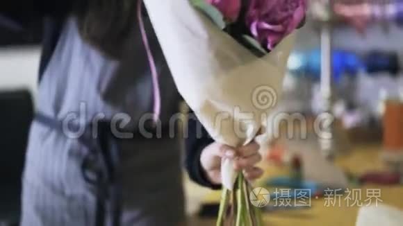 花店员工包着一束紫色的花视频