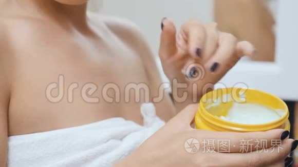 女性用奶油滋润她的皮肤视频