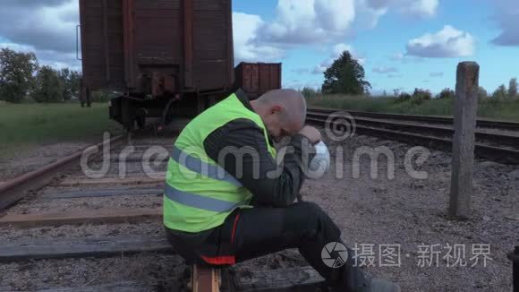 压力很大的铁路工人坐在铁轨上视频