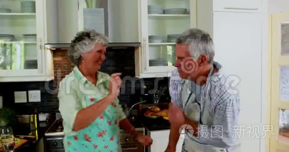 浪漫的高级夫妻在厨房跳舞视频